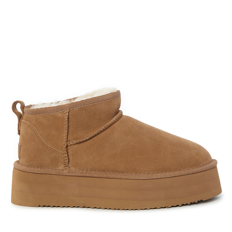 Side view of chestnut platform mini UGG boots made with soft suede and warm sheepskin lining, classic Australian winter ankle boots with thick platform sole