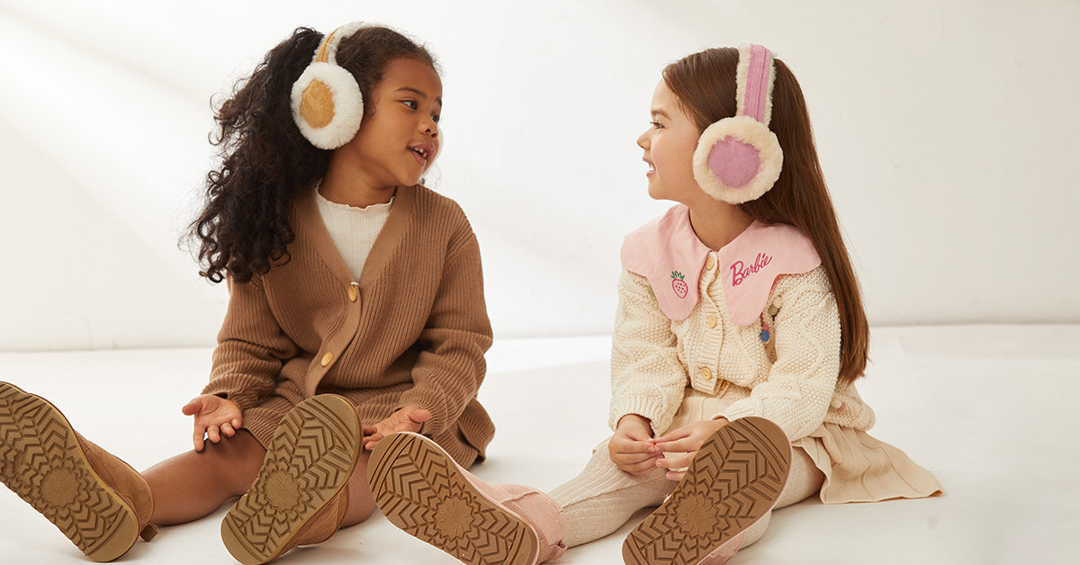 two little girls wearing matching UGG Earmuffs and UGG boots