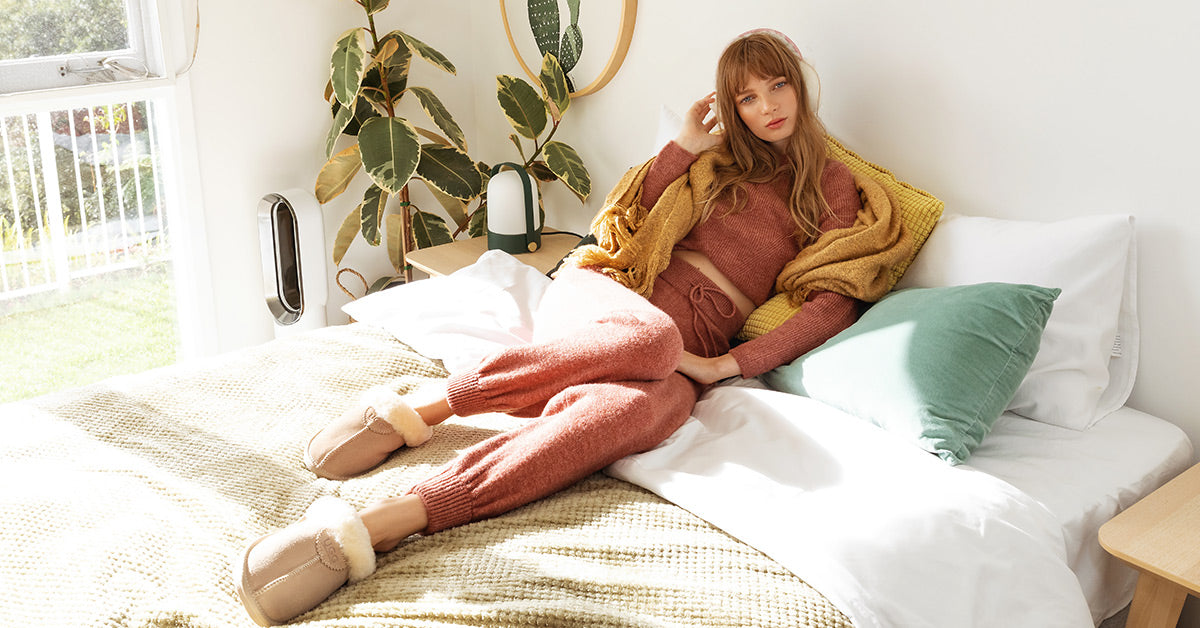 a woman lying on her bed for a comfy Sunday while wearing UGG boots